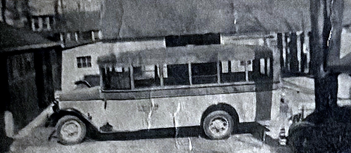 A 1930s school bus parked in front of Beaver Lake Garage.